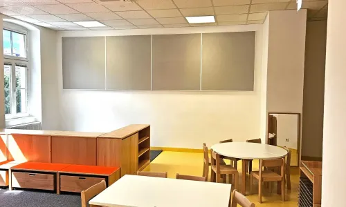 Gruppenraum mit Tischen, Sitzm&ouml;beln und akustischen Wandpaneelen