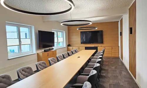 Besprechungsraum mit Holzlamellenwand und moderner Wandbeleuchtung