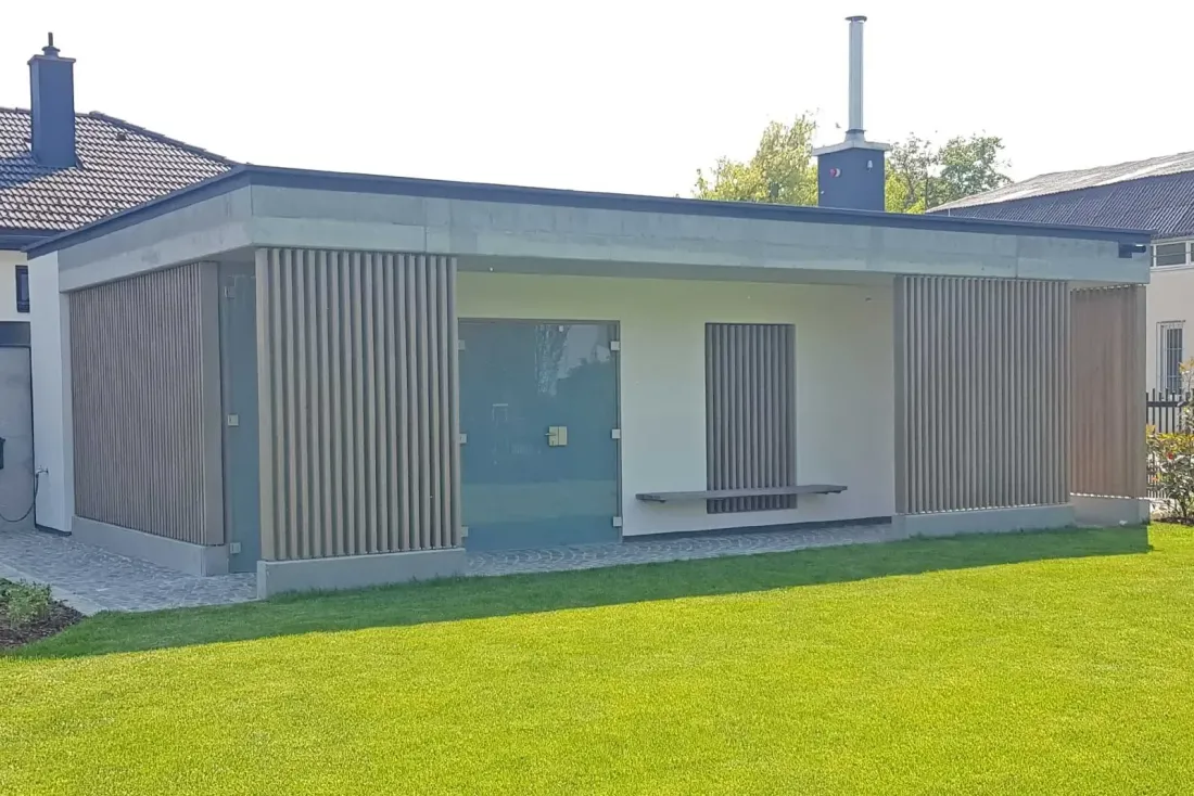 Nebengebäude mit Holzfassade und integrierter Glastür, reduziert und klar gegliedert