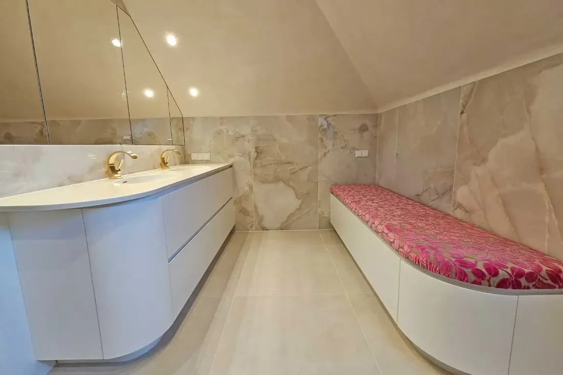 Modernes Bad mit Doppelwaschtisch, Natursteinwand und integrierter Sitzbank