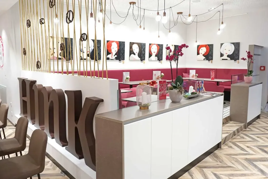 Cafébereich mit Sitznischen, Kunstbildern und dekorativer Beleuchtung