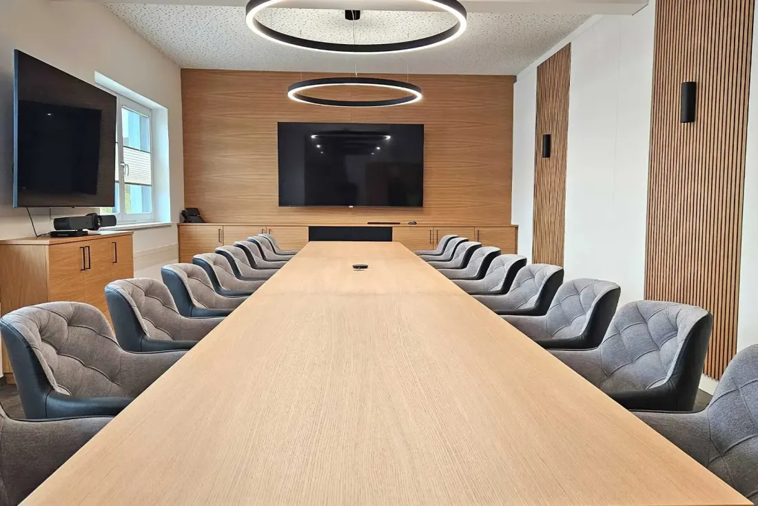 Besprechungsraum mit maßgefertigtem Tisch und Holz-Akustikwand