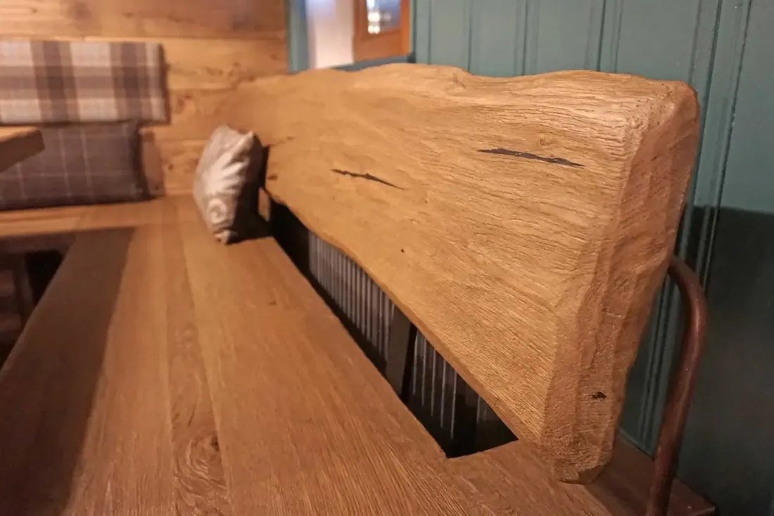 Rustikale Holzbank mit massiver Rückenlehne und Sitzfläche