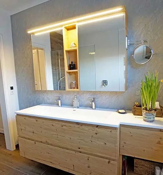 Modernes Badezimmer mit Holzwaschtisch, großem Spiegel und indirekter Beleuchtung